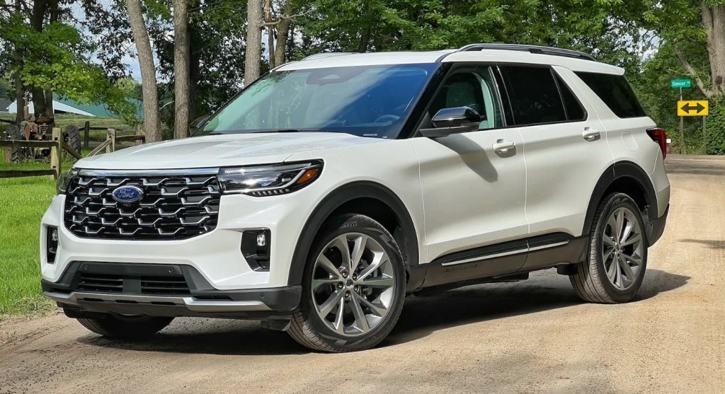 A white Ford Explorer sits on a dirt driveway.