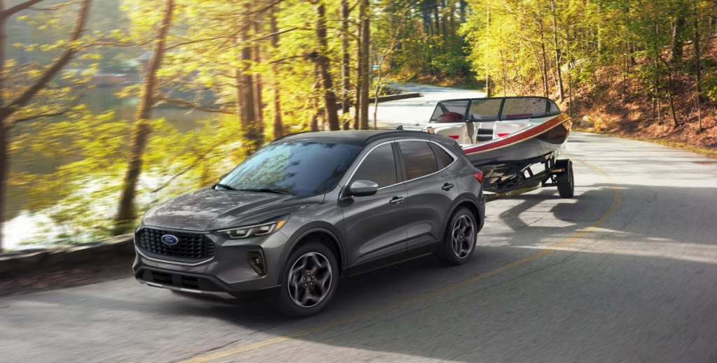 The 2026 Ford Escape tows a boat behind it down a fall road. Shop for your new 2026 Ford Escape at Summerville Ford near Charleston.