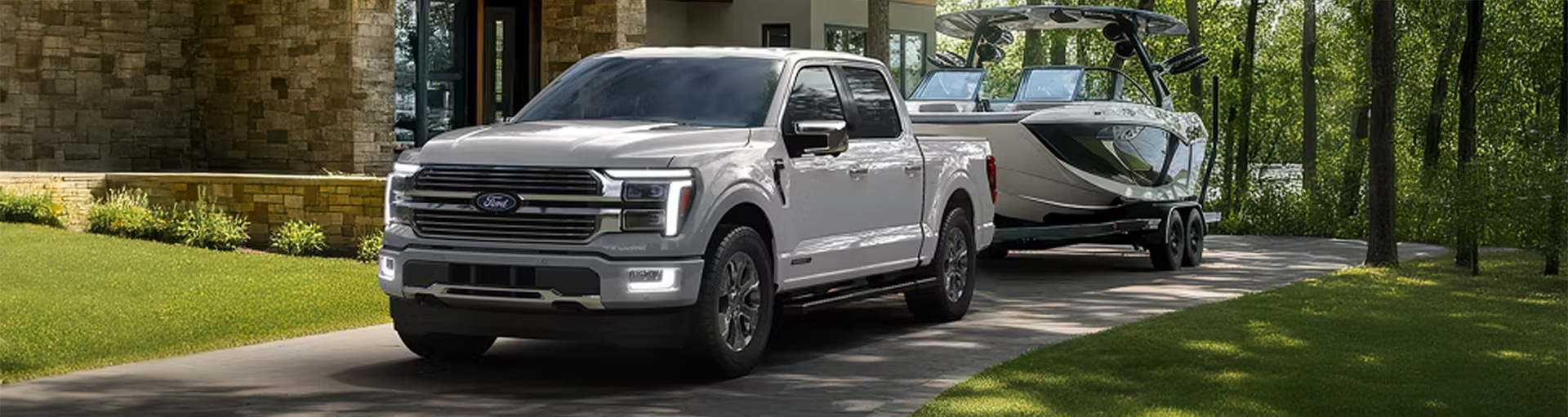 A silver Ford F-150 with a boat attached.