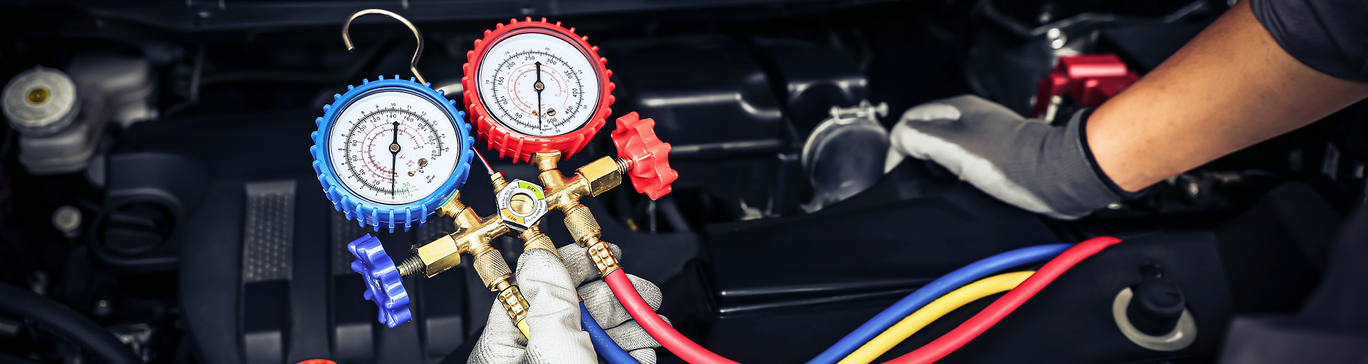 Close-up of a service technician working on a vehicle's engine.